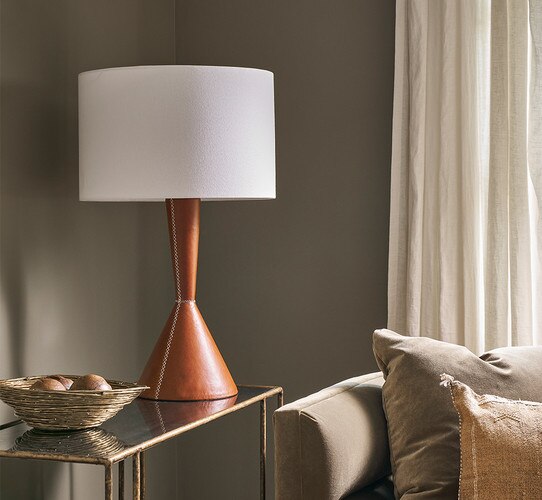 Leather table lamp with flared base on a gold console table