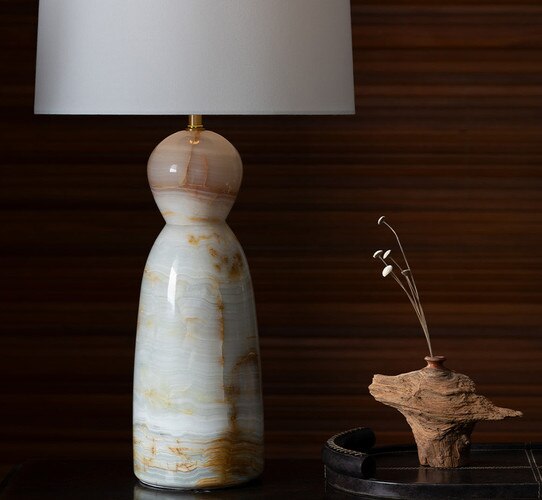 Jade table lamp next to a naturally formed vase with three faux florals