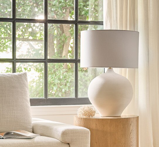 Smooth white table lamp on a drum wood side table