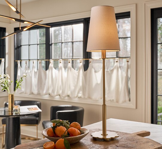 Brass buffet lamp with scalloped base next to a bowl of clementines
