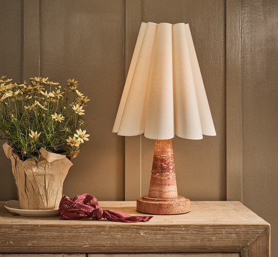 Red marble mini lamp with scalloped ahde on a wood console table