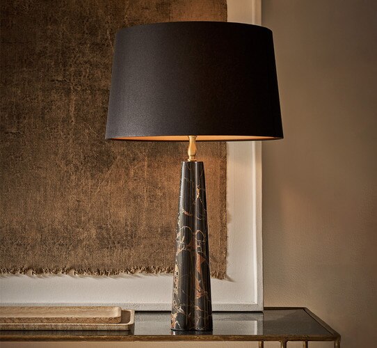Black marble table lamp on a console table in front of a painting