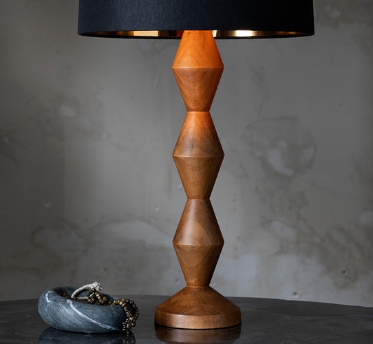 Wood buffet lamp with black shade next to a marble dish