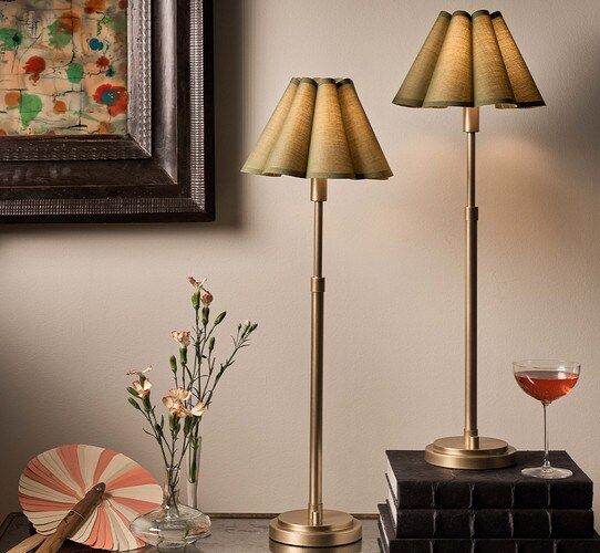 Brass buffet lamp with scallopped green shade on a console table