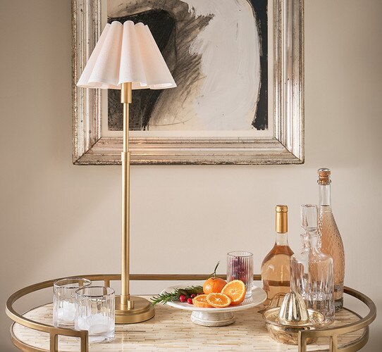Brass buffet lamp with white scalloped shade on a bar table