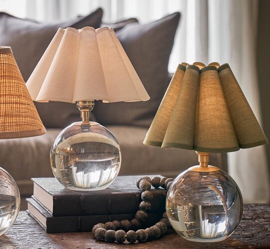Three crystal mini lamps with scallped shades on a coffee table