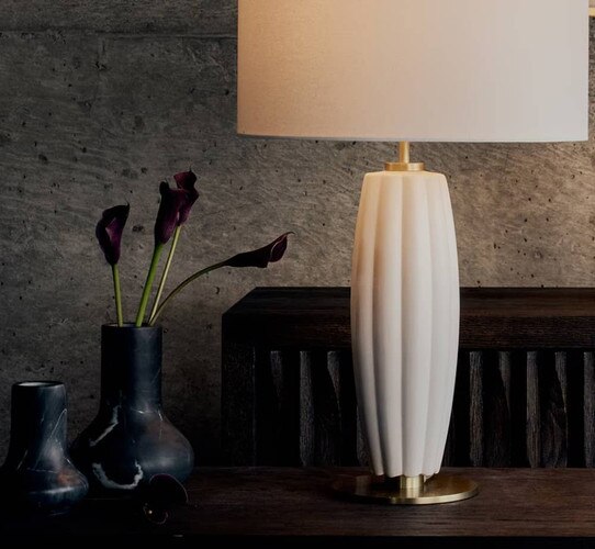 White lamp beside two marble vases holding flowers