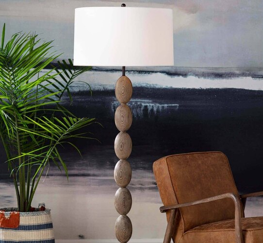 Wooden buoy-like floor lamp next to a leather accent chair