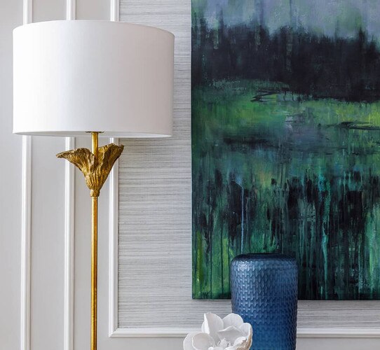 Traditional antique gold lamp next to white wall and landscape paintings