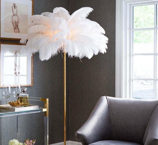 Ostrich feather gold lamp next to a gray accent chair