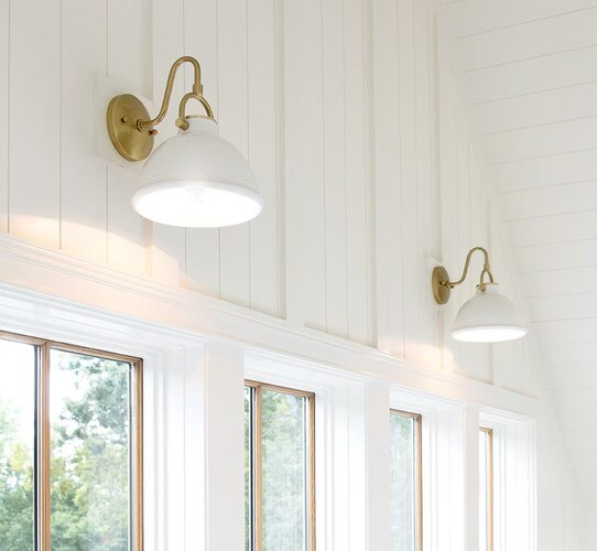 Brass and white sconces above windows