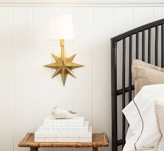 Brass star sconce above a bedside table