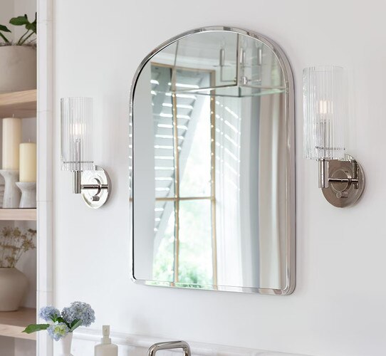 Polished nickel mirror with polished nickel wall sconces flanking it