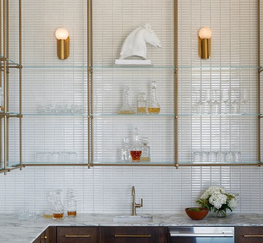Brass sconce with Alabaster light above brass and glass bar shelves