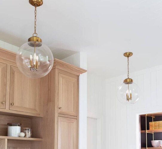 Brass globe pendants hung from a white ceiling