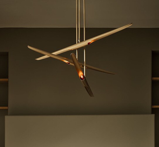 Brass multi armed chandelier in front of a green fireplace