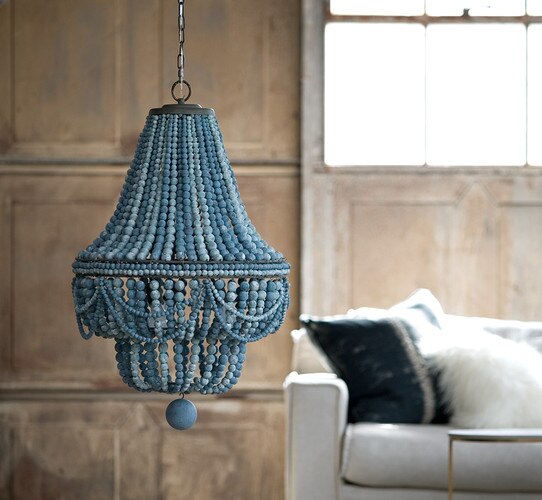 Large blue beaded chandelier above a white sofa