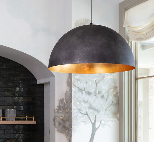 Black and gold pendant light in front of a kitchen nook
