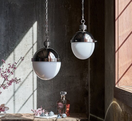 Polished nickel pendant lights in front of a window