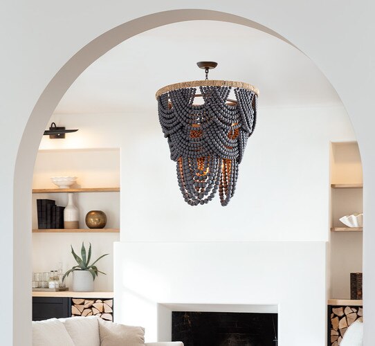 Black and wicker beaded chandelier above a coffee table and white sofa in a living room