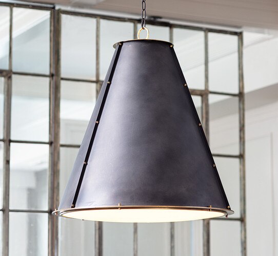 Black cone shaped chandelier in front of a metal door