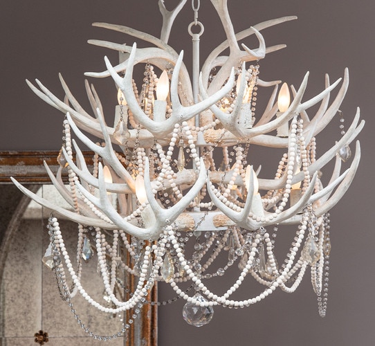 Antler and beaded crystal chandelier in front of a mirror
