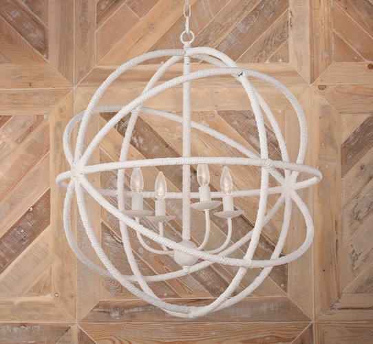Large white rattan chandelier in front of a wood wall