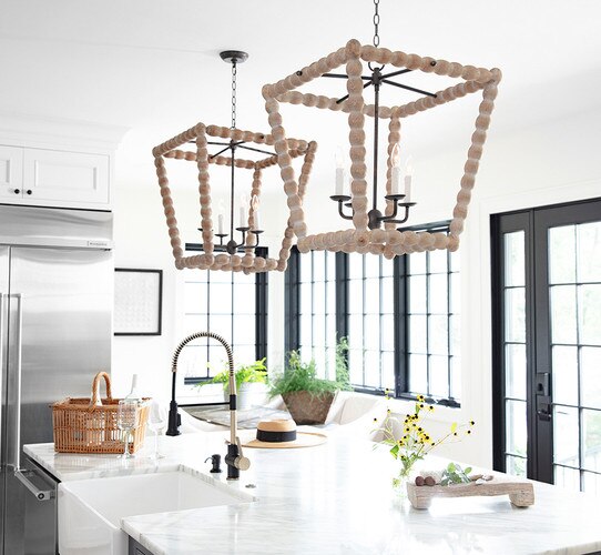 Large wood lantern with metal arm bodys above a kitchen island