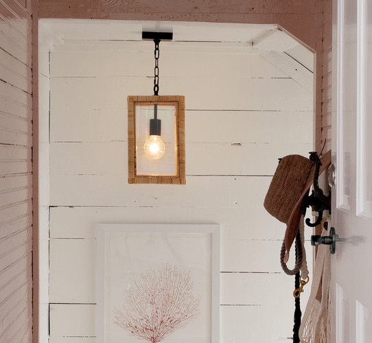 Glass and rattan pendant light above a picture in a stairwell