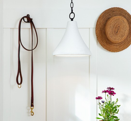 White concrete pendant beside a leash and hat