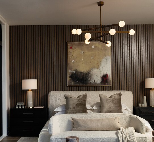 Modern tiered chandelier with horizontal arms above a bed