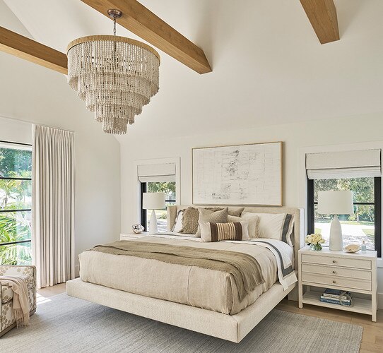 Tiered white beaded chandelier above a bed and nightstands