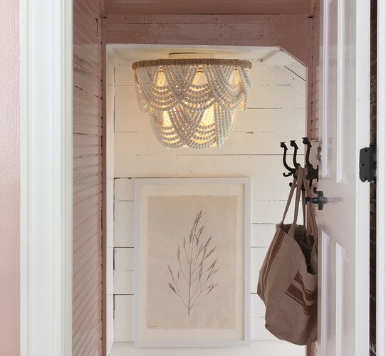 White beaded flush mount above a pink picture frame