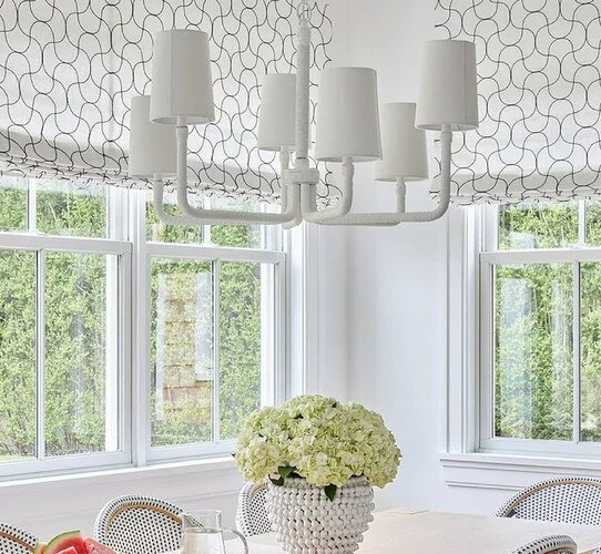 Breakfast nook with white chandelier and potted flowers