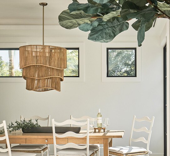 Tiered wicker chandelier above a wood dining table with chairs