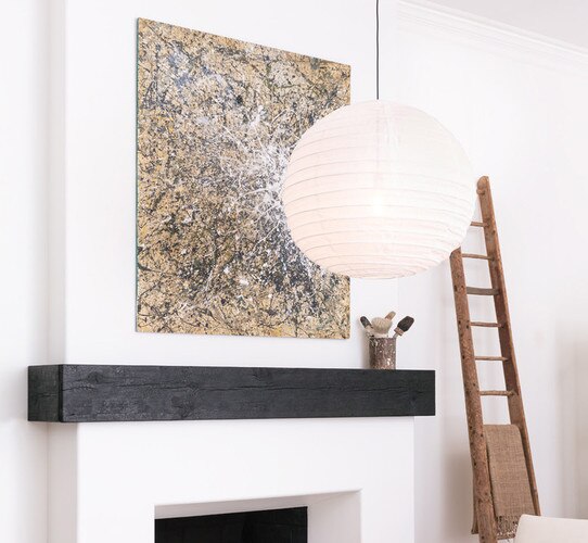 Paper lantern pendant in front of fireplace with large abstract painting above it