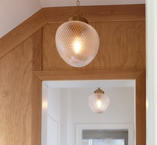 Studded glass pendant in front of a wood doorway