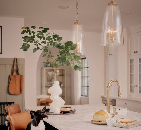 Brass pendants over a marble kitchen island