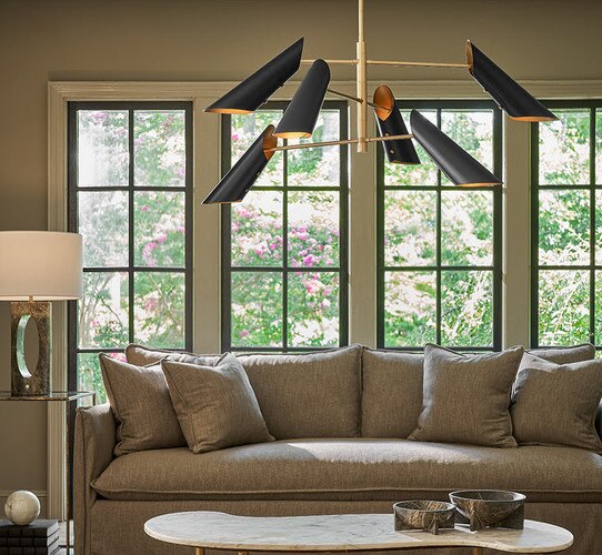 Brass and black chandelier above a marble coffee table in a living room