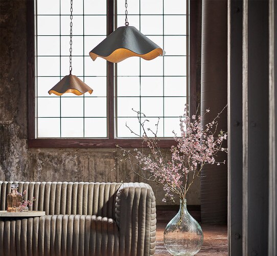 Two scalloped pendant lights above a brown leather sofa