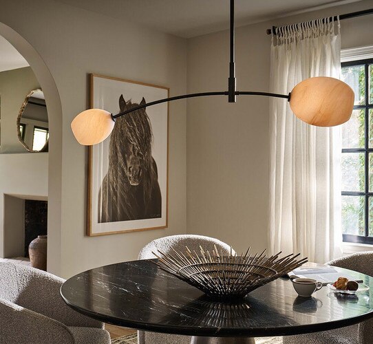 Double-armed oil rubbed bronze pendantabove a circular marble dining table