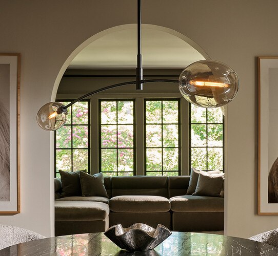 Oil-Rubbed bronze pendant above a marble dining table with a small bowl in the center