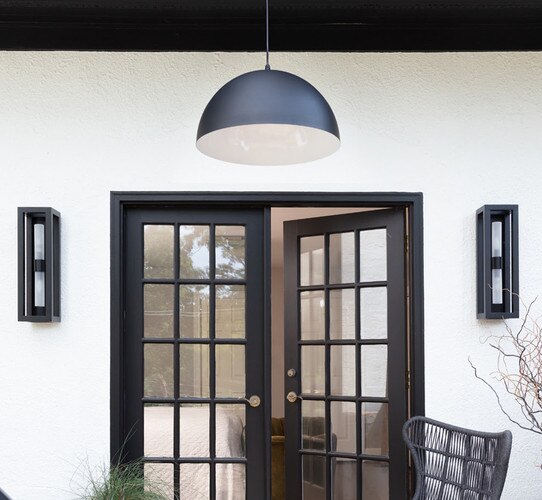 Black front door with a black and white outdoor pendant light above it