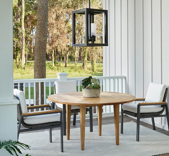 Porch with round wood dining table black pendant light and chairs