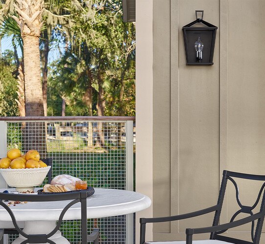 Patio with white dining table and black wall sconce