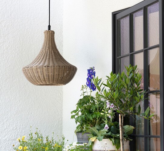 Brown pentant light in front of a window with flower boxes