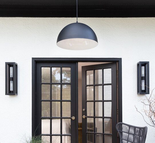 black front door with a pendant light and black wall sconces on the side