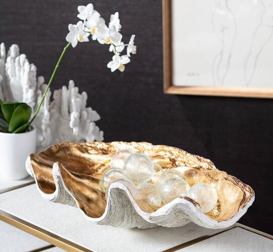 Gold clam bowl with frosted glass bulbs beside a potted flower