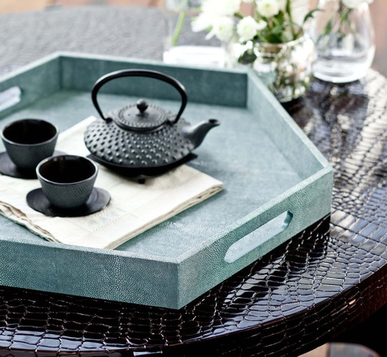 Turquoise shagreen tray with a metal teapot and cups on it