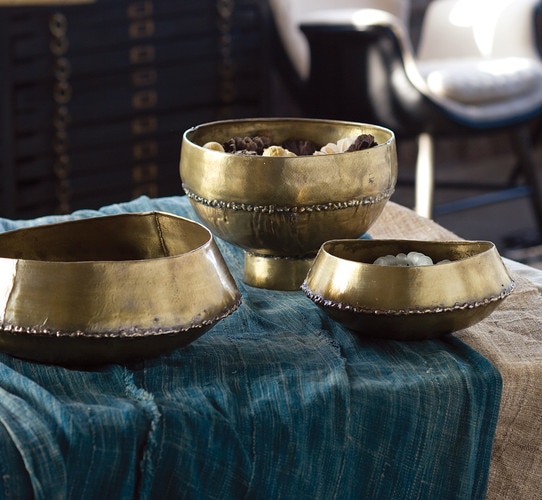 Three brass bowls of differing size on a piece of cloth